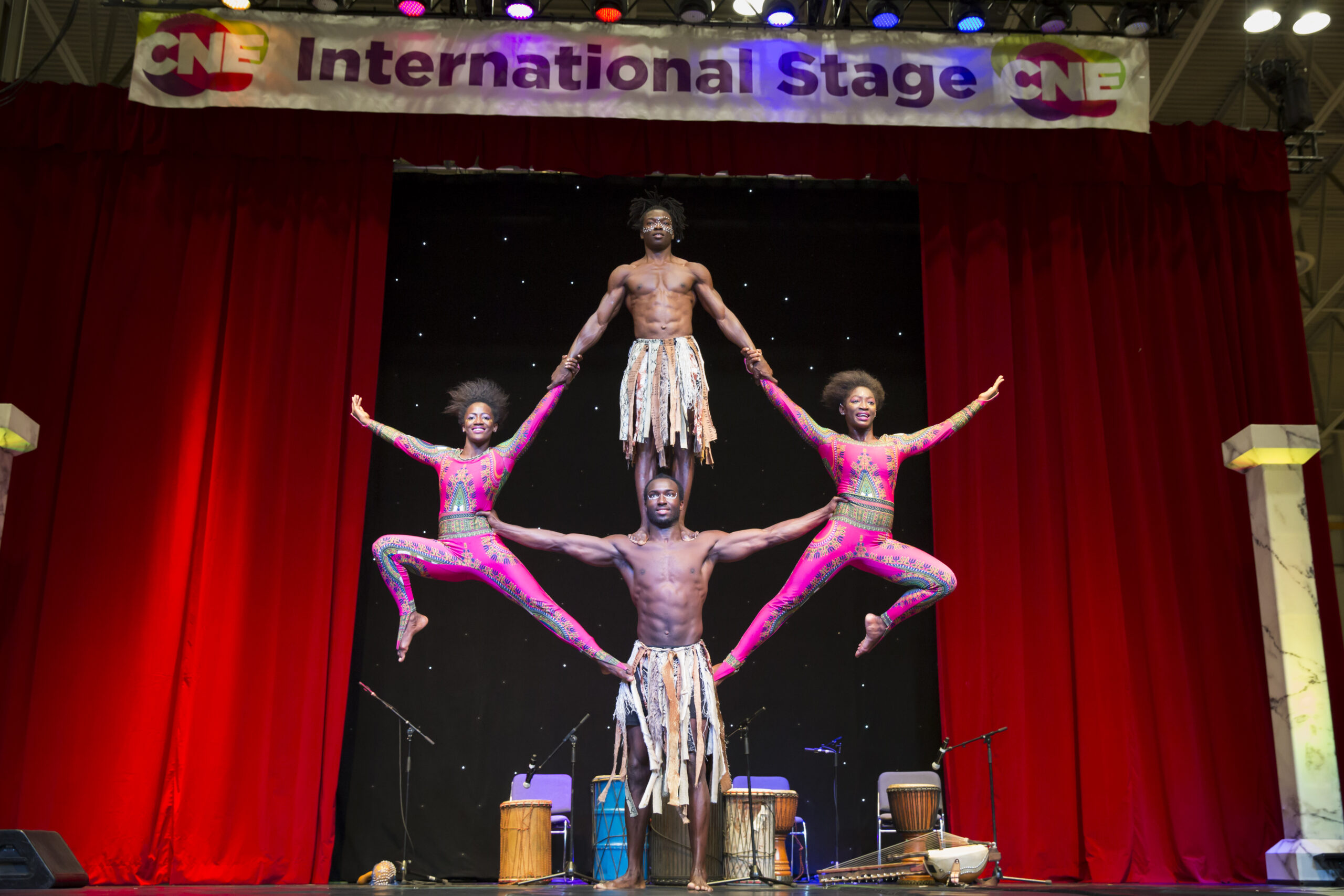 Image of International stage performers. Artists performing an acrobatic maneuver in formation.