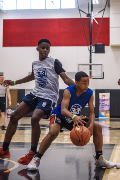 Two young men playing basketball.