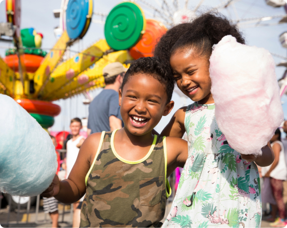 Image of two children enjoying cotton candy in the midway.