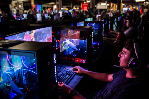 Boy wearing gaming headset playing a game at a computer in the Gaming Garage Powered by AMD.