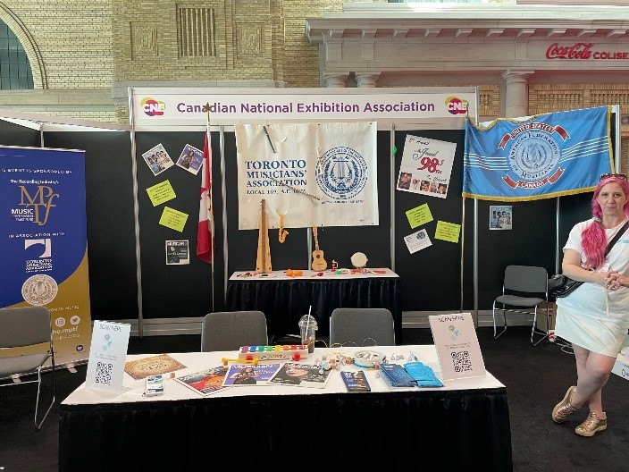 CNE Association Membership Exhibit. Image of the booth with posters, print outs and a person standing with the exhibit.