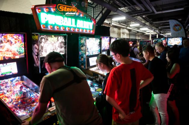 People playing pinball in the CNE Gaming Garage Powered by AMD