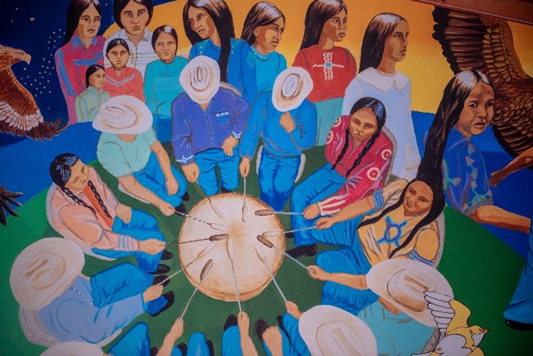 The Mississaugas of the Credit First Nation Exhibit mural. Mural of Indigenous people sitting around in a drum circle.
