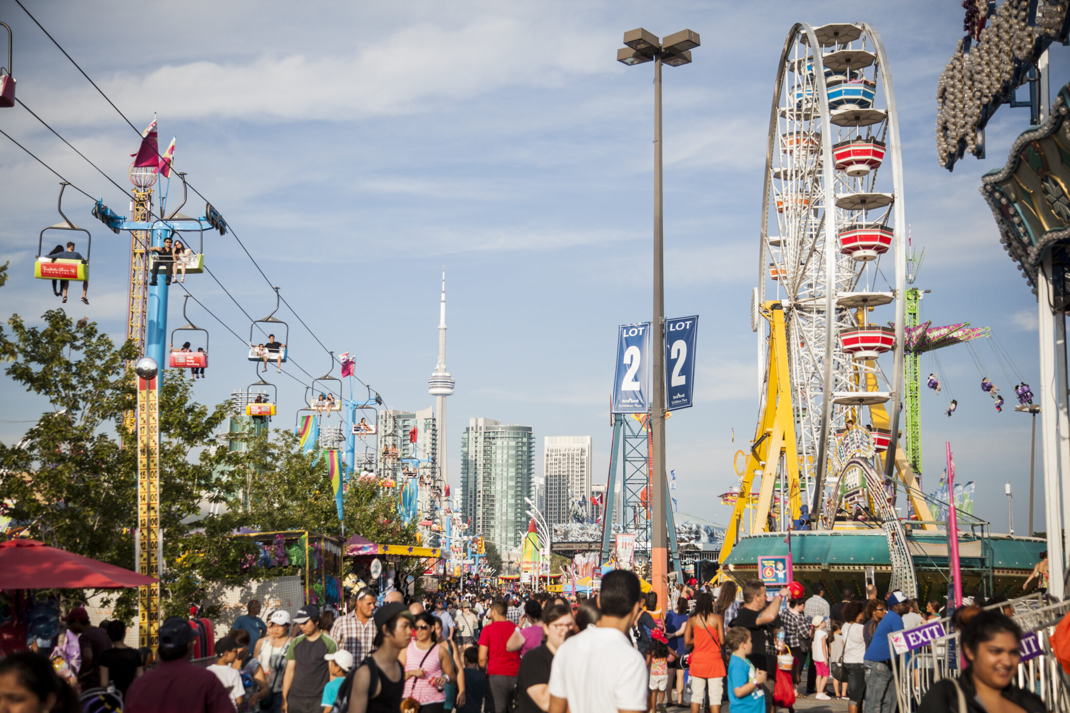 The view is as if you are in a sea of people in the middle of the Midway facing the ferris wheel