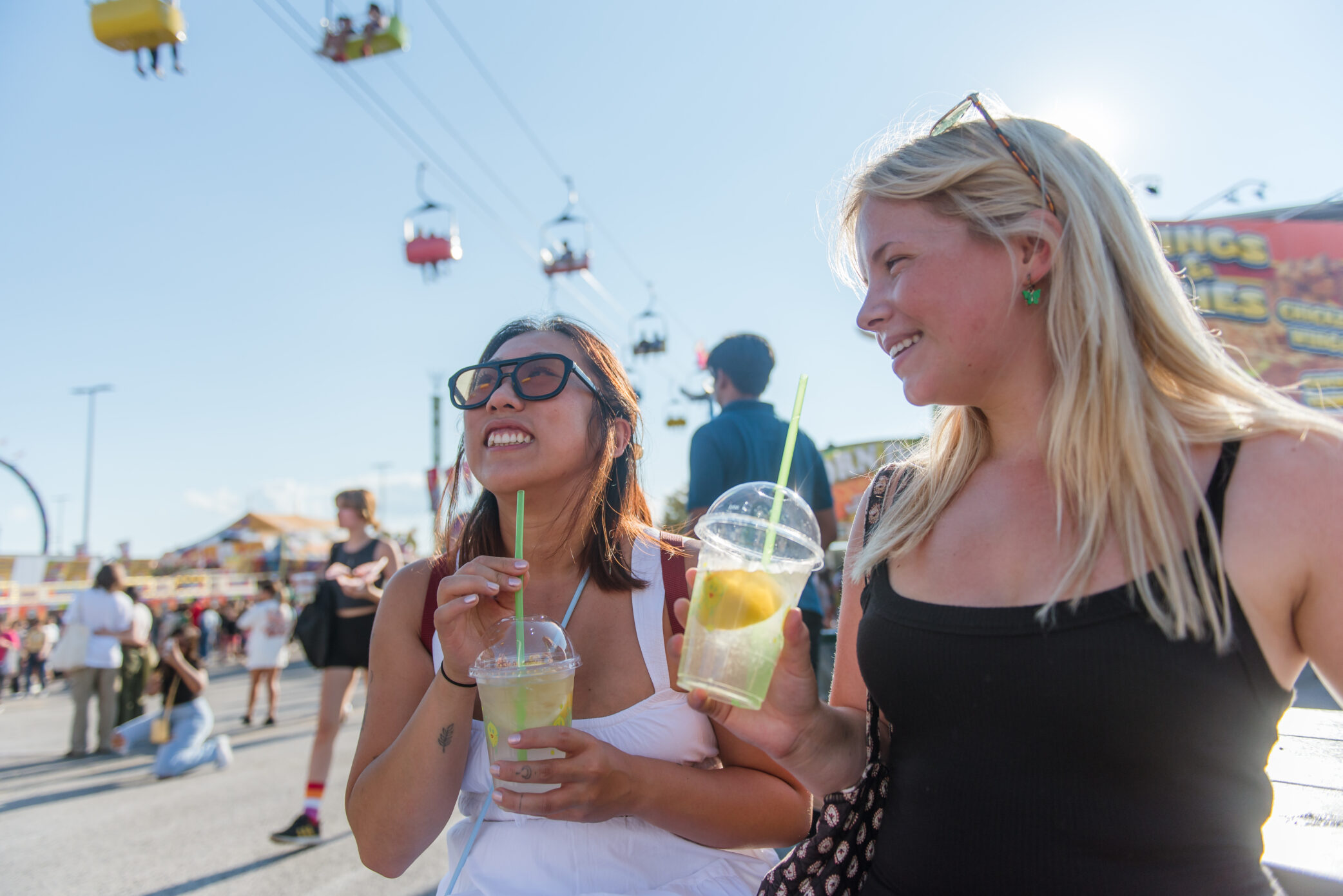 Two females drinking lemonade in the midway